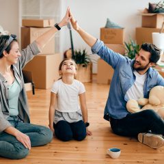 Happy parents making rooftop above daughter's head after moving into their new home.